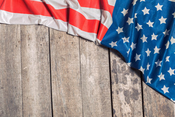 An American Flag Lying on an aged, weathered rustic wooden background