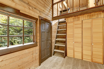 Wooden house entryway with wardrobe and ladder