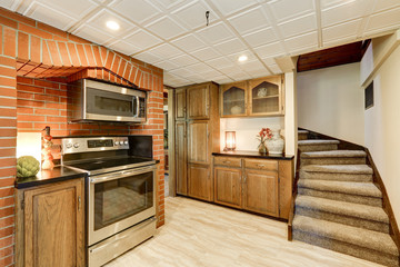 Kitchen area with red brick wall and built in appliances