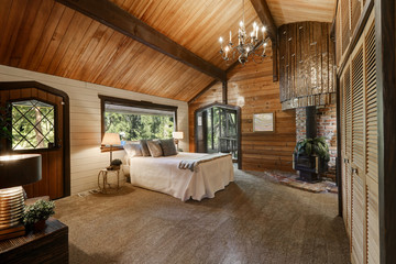 Wooden bedroom interior with high vaulted ceiling