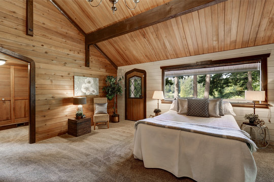 Wooden bedroom interior with high beamed ceiling