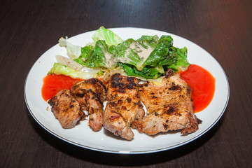 Grilled steaks, baked potatoes and vegetable salad