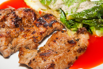 Grilled steaks, baked potatoes and vegetable salad