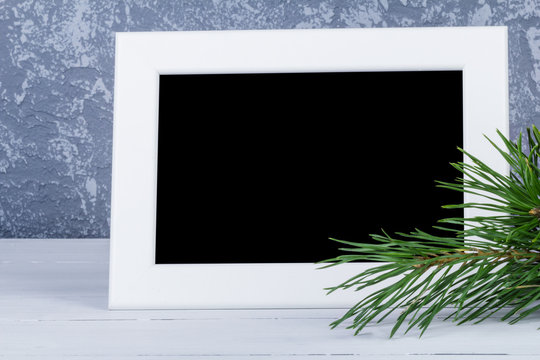 Photo frame behind christmas trees branch