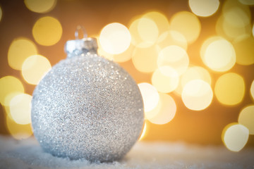 Christmas glass ball in snow. Glitter lights background