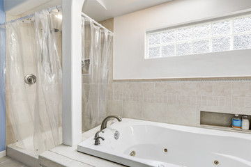 White clean bathroom with beige tile trim and small window