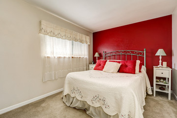 Bright woman's bedroom with red contrast wall