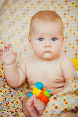 Calm boy plays with a toy on bed
