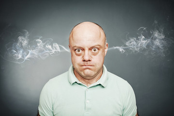 Closeup portrait of angry man, blowing steam coming out of ears,
