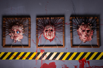 Bloody ghastly skins from human heads stuck in square frames