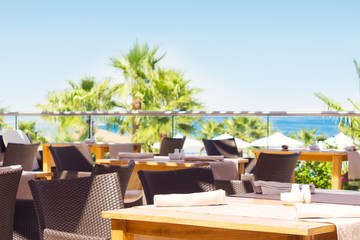 outdoor terrace of restaurant overlooking the sea and palm trees