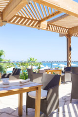 outdoor terrace of restaurant overlooking the sea and palm trees