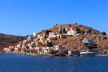 Fototapeta na wymiar Symi island - Colorful houses and small boats at the heart of the village