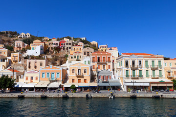 Fototapeta na wymiar Symi island - Colorful houses and small boats at the heart of the village