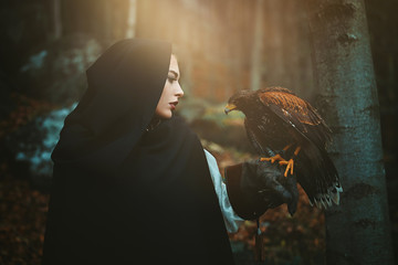 Dark hooded woman and hawk