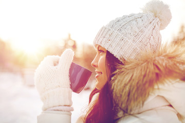 happy young woman with tea cup outdoors in winter