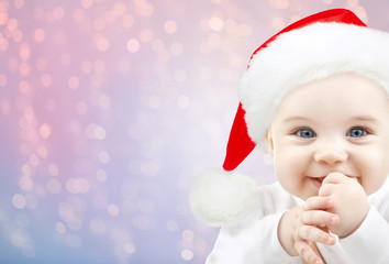 happy baby in santa hat over holidays lights