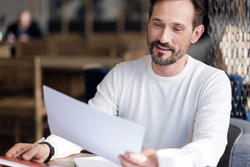 Fototapeta premium Smiling bearded man holding paper