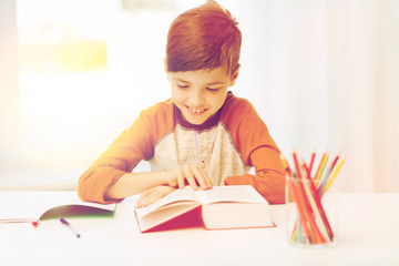 smiling, student boy reading book at home