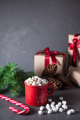 Hot chocolate or cocoa with marshmallows on gray background. Christmas presents. Holiday concept.