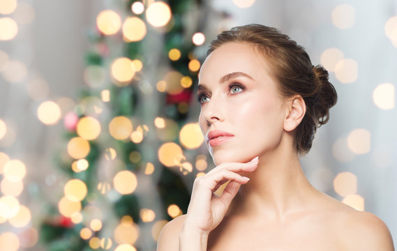 beautiful woman face over christmas lights