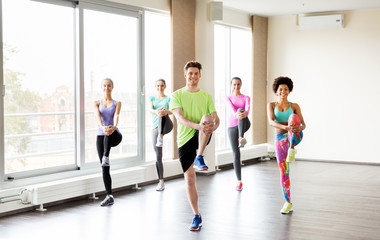 Obraz premium group of smiling people exercising in gym