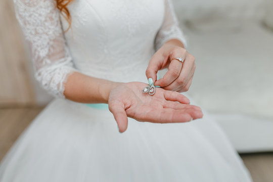 Wedding earrings on a bride's hand, bridal morning fees