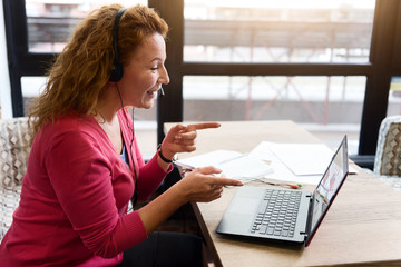 Smiling ginger woman talking per skype