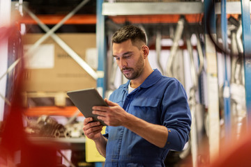 auto mechanic or smith with tablet pc at workshop