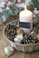 weiße Kerze mit Dekoration zu Weihnachten