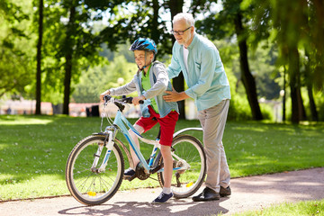 Fototapeta premium grandfather and boy with bicycle at summer park