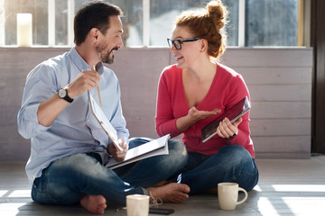 Middle-aged couple sitting on floor near window