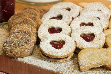 cookies and biscuits presented on a wooden board with ingredients next to it