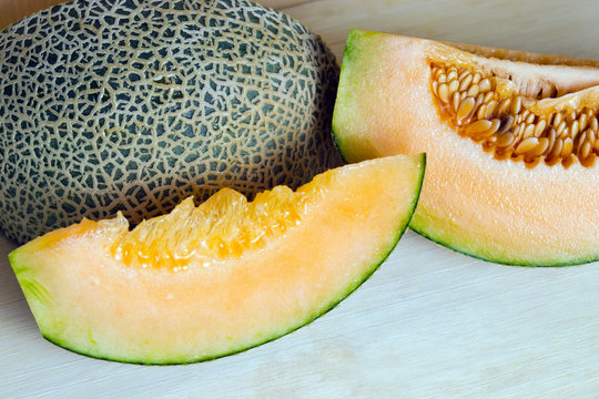 Melon or cantaloupe sliced on wooden board with seeds (Also call
