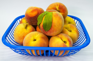 basket of fresh peaches on  white