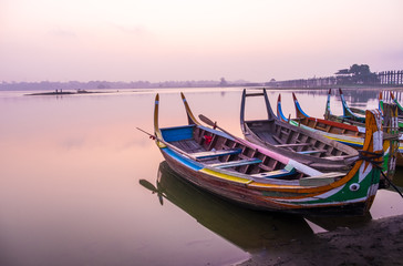 Fototapeta na wymiar Sunrise scene with boat at lake at Ubeng bridge,Mandalay,Myanmar