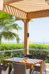 outdoor terrace of restaurant overlooking the sea and palm trees
