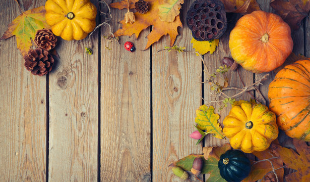 Thanksgiving dinner background. Autumn pumpkin and fall leaves on wooden table. View from above