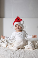 kid in Santa hat playing on bed  home, light , New Year's concep