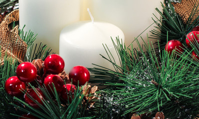 Christmas wreath with pine cones, berries and candles