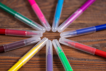 Naklejka premium colored felt-tip pens on a wooden table background, the concept