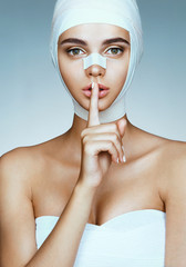 Shhh! It's a secret. Girl in medical bandage after operation wants to keep her plastic surgery in...