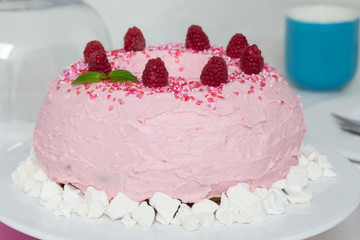 gugelhupf mit rosa buttercreme und Himbeeren