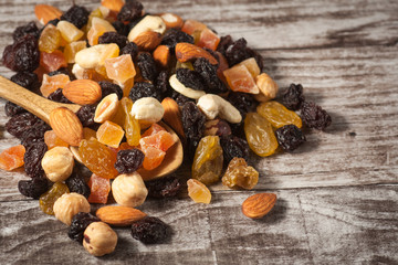Nuts and dried fruits mix on a rustic sack and wooden background
