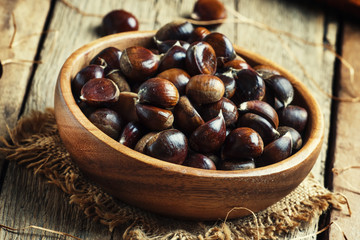 Fresh edible chestnuts in bowl, still life in rustic style, vint