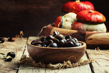 Fresh edible chestnuts in bowl, still life in rustic style, vint