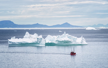 Boot vor Eisbergen in Grönland