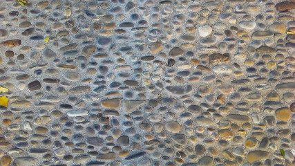 small stone cobbles on the pavement, a stone on the wall