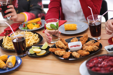 People with drinks while sitting at the dining table
