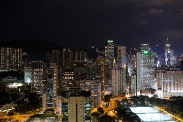 Fototapeta na wymiar Night panorama of Hong Kong. City with illuminated high-rise buildings, roads and football fields